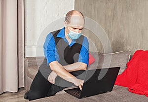 Business man in surgical virus protection mask working at home. Quarantine and pandemic concept