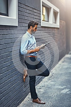 Business man, tablet and research on internet, reading email or info online on a wall in city. Serious, digital tech and