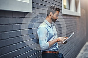 Business man, tablet and web research, reading email or info online on a wall in urban city. Serious, digital tech and