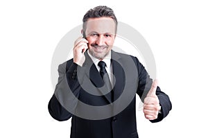 Business man talking on the phone and showing thumb up