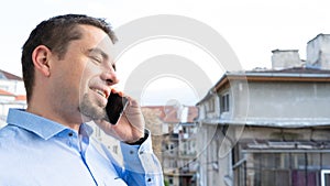 Business man talking on phone. Young guy calling by cellphone smiling