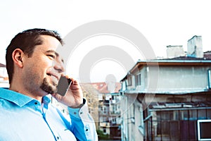 Business man talking on phone. Young guy calling by cellphone smiling