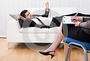 Business man talking to his psychiatrist explaining something photo