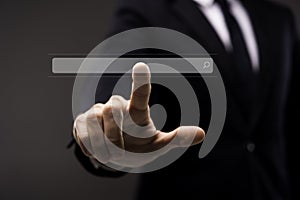 Business man touching imaginery screen with search