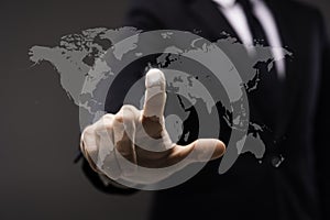 Business man touching imaginery screen with world map