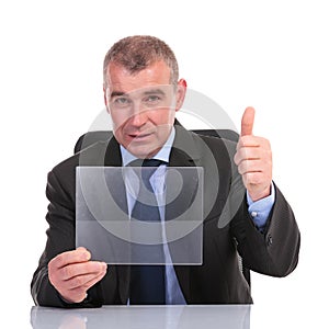 Business man with transparent pannel shows thumb up