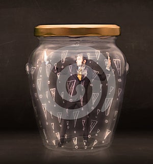 Business man trapped in jar with exclamation marks concept