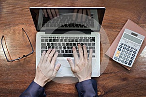 Business man type on loptop in his office, top view
