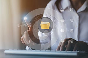business man typing on a keyboard with holograms of digital document files, data files on computers stored as cloud databases can