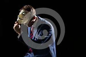 Business man under the mask disguise being Anonymous and implying that he is a hacker or anarchist