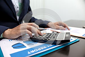 Business man using a calculator to calculate financial accounts