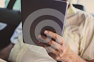 Business man using digital tablet in car.