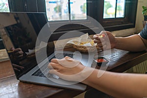 Business man using laptop computer, hand typing notebook keyboard and eating fast food French fries with ketchup..Sedentary