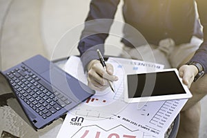 Business man using laptop and smartphone and tablet for analytic financial graph year 2017 trend forecasting planning outdoor pla