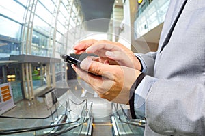 Business Man Using Mobile while going down Escalator