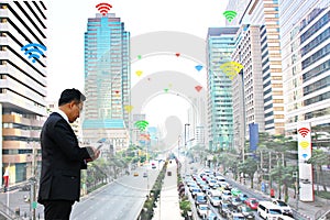 Business man using mobile phone communicate  by inter net wifi  which has many service providers in city