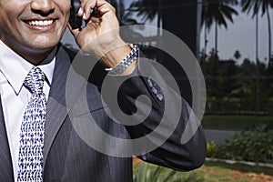 Business man using mobile phone outdoors