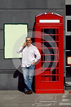 Business man using mobile phone red classic English telephone bo