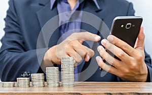 Business man using smart phone and growing money coin