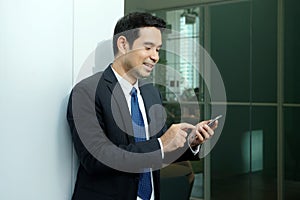 Business man using smart phone with happy smiling face standing