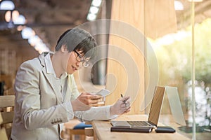 Business man using smartphone and checking his work