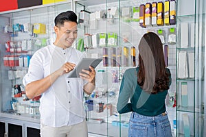 business man using a tablet and a woman looking at and selecting accessory products