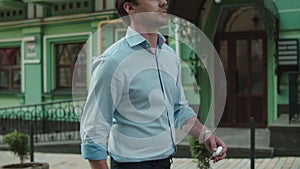 Business man using wireless earphones outdoor. Man talking by earphone outside