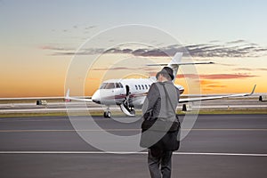 Business man walking toward a private jet