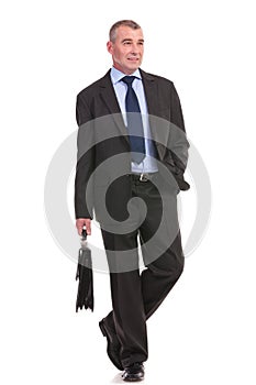 Business man walks toward the camera with briefcase