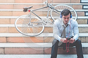 Business man watch Video on mobile with his bicycle on the side