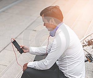 Business man watch Video on mobile with his bicycle on the side