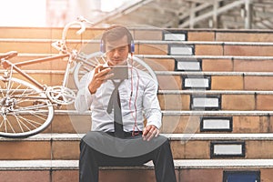 Business man watch Video on mobile with his bicycle on the side