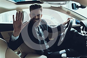Business Man Waving Hand while Driving Car