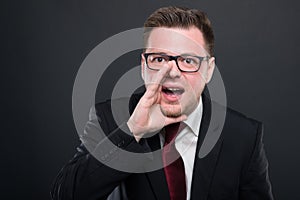 Business man wearing black suit screaming out loud photo