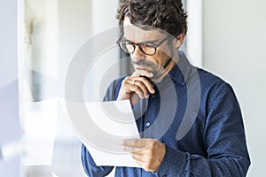 Business man wearing glasses  holding paper document.