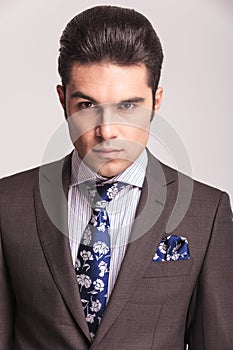 Business man wearing a grey suit and blue tie.