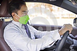 Business man wearing protective  medical mask and driving in the car during coronavirus outbreak