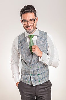 Business man wearing white shirt, grey vest and green tie.