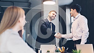 Business man welcoming new employee, shaking hands