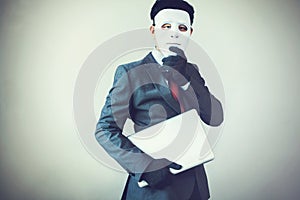 Business man in white mask wearing gloves and stealing computer and digital information - fraud, hacker, theft, cyber crime