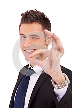 Business man winking with ok sign