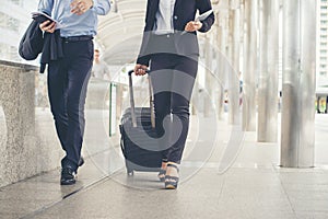 Business man and woman  Dragging suitcase luggage bag,walking to passenger boarding in Airport,travel to work.Asian tourist men