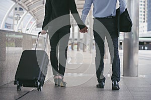 Business man and woman  Dragging suitcase luggage bag,walking to passenger boarding in Airport,travel to work.Asian tourist men