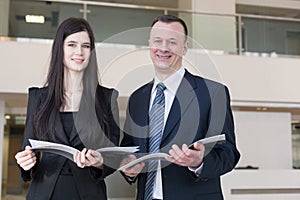 Business man and woman are holding magazines photo