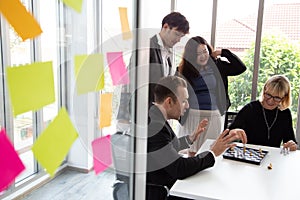 Business man and woman are playing chess together on table. Play in the team during a working break.