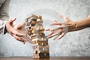 Asian man and woman playing wood jenga game. photo