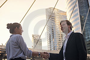 Business man and woman shake hands in city