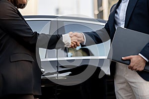 Business man and woman shaking hands outdoors