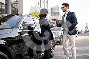 Business man and woman shaking hands outdoors