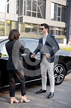 Business man and woman shaking hands outdoors